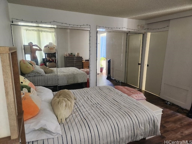 bedroom featuring a textured ceiling and dark hardwood / wood-style flooring