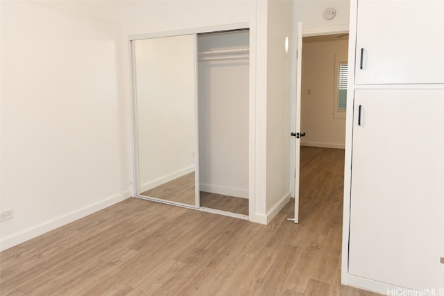 unfurnished bedroom featuring a closet and light wood-type flooring