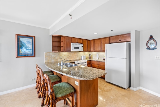 kitchen featuring white appliances, light stone countertops, backsplash, kitchen peninsula, and crown molding