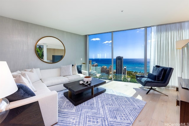 living room with floor to ceiling windows, hardwood / wood-style floors, and a water view