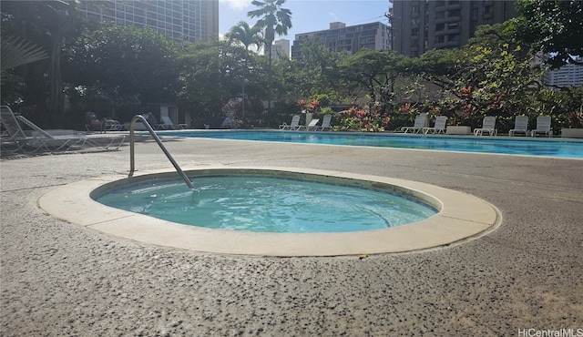 view of swimming pool featuring a hot tub