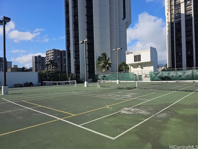 view of sport court featuring a city view and fence