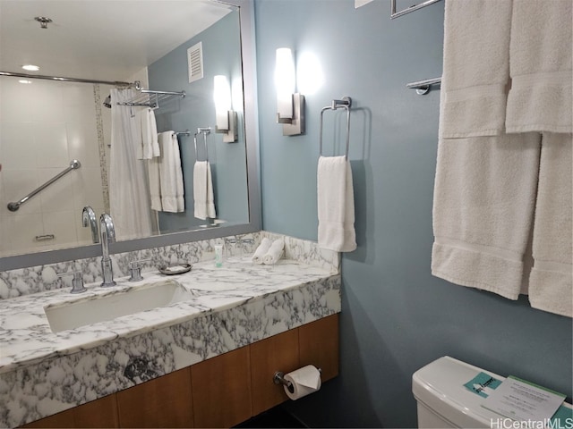 bathroom with toilet, vanity, and a shower with shower curtain