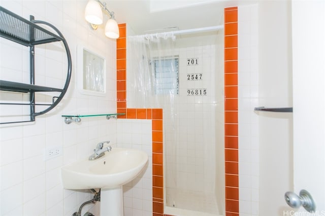 bathroom featuring sink, tile walls, and tiled shower