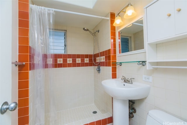 bathroom featuring toilet, tile walls, curtained shower, and backsplash