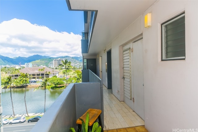 balcony featuring a water and mountain view