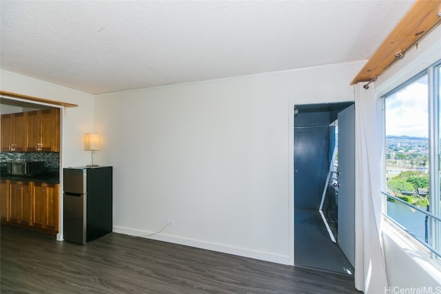 interior space with a textured ceiling and dark hardwood / wood-style flooring