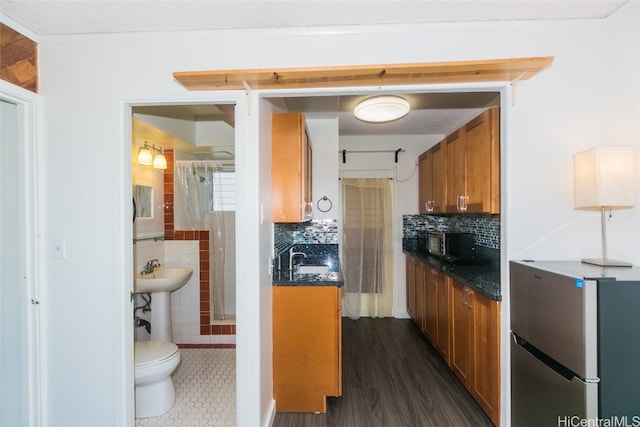 kitchen featuring dark wood-type flooring, appliances with stainless steel finishes, and decorative backsplash