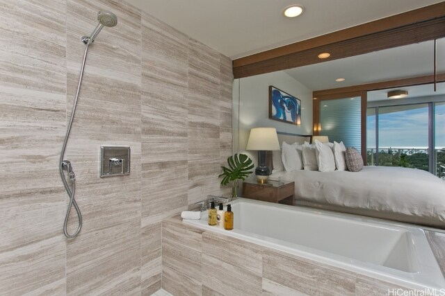 bathroom with tile walls and separate shower and tub