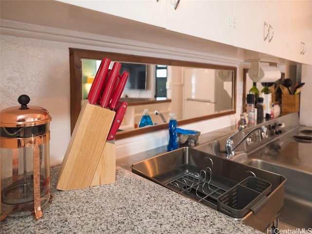 kitchen featuring white cabinetry and sink