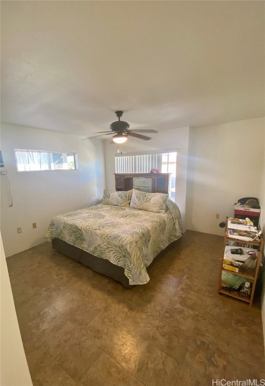 bedroom featuring multiple windows and ceiling fan