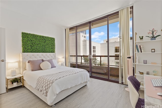 bedroom with access to outside, floor to ceiling windows, and hardwood / wood-style floors