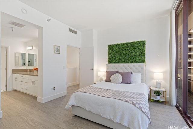 bedroom featuring light hardwood / wood-style floors and ensuite bath