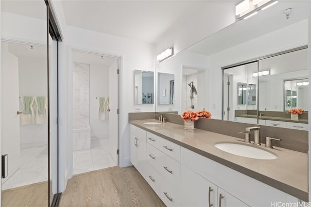 bathroom featuring vanity, wood-type flooring, and tiled shower