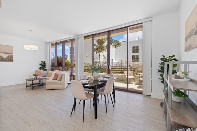 dining area featuring light wood-type flooring and floor to ceiling windows