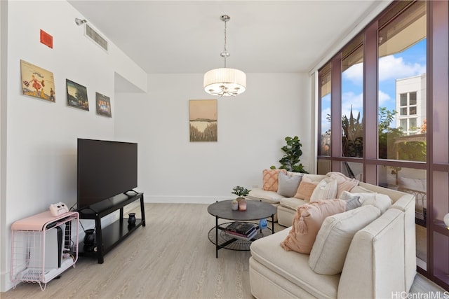 living room featuring light hardwood / wood-style floors and a notable chandelier