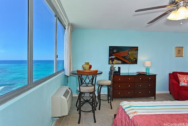 tiled bedroom with a water view and ceiling fan