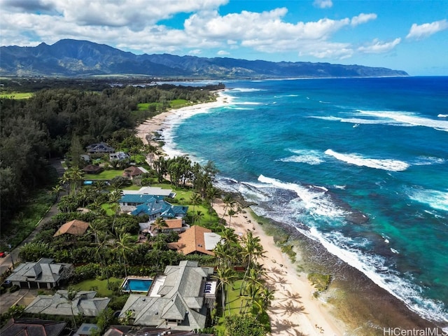 drone / aerial view with a beach view and a water and mountain view