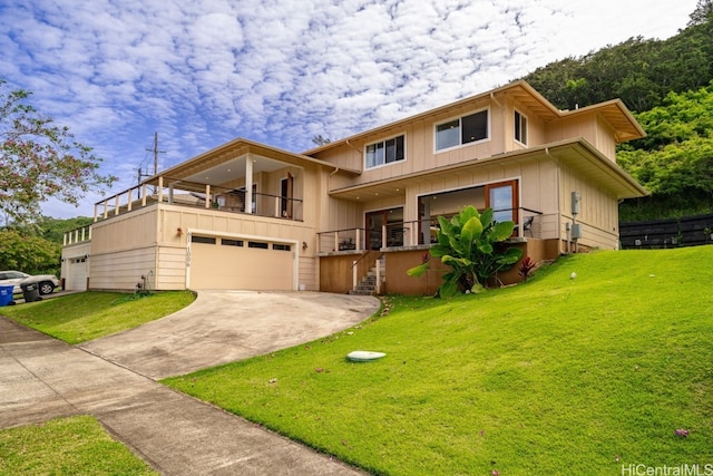 view of front of home with a front yard, a garage, and a balcony