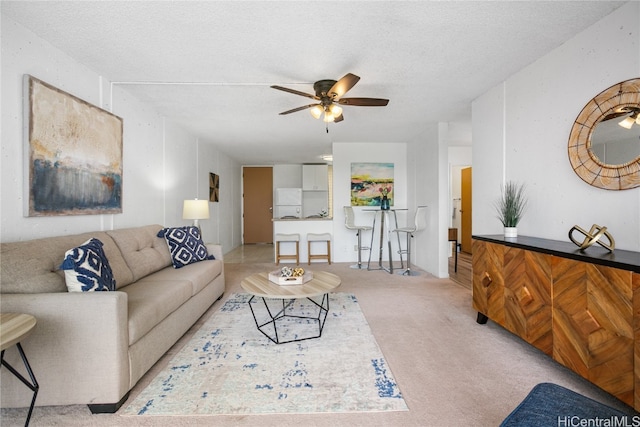 carpeted living room featuring a textured ceiling and ceiling fan