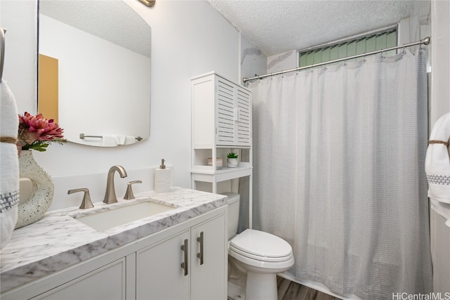 bathroom featuring toilet, hardwood / wood-style floors, a shower with shower curtain, vanity, and a textured ceiling