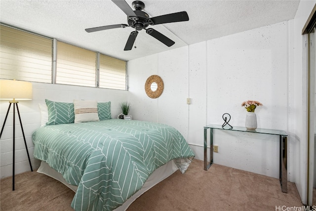 bedroom featuring a textured ceiling, carpet floors, and ceiling fan