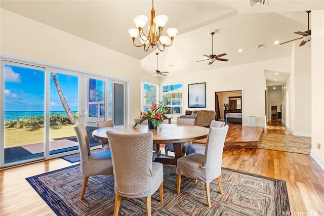 dining space with a notable chandelier, hardwood / wood-style flooring, and high vaulted ceiling