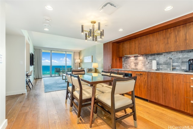 dining room with light hardwood / wood-style floors, a chandelier, and sink