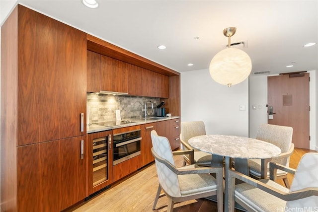 dining area featuring recessed lighting, visible vents, bar area, and light wood-style flooring