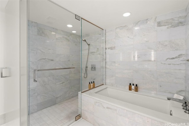 bathroom with a marble finish shower and a garden tub