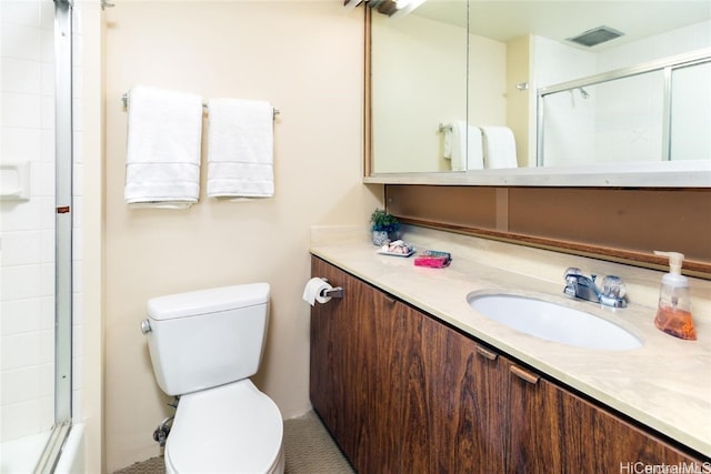 bathroom with toilet, a shower with shower door, and vanity