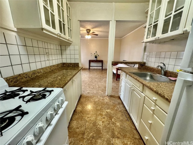 kitchen with tasteful backsplash, sink, refrigerator, white gas range, and ceiling fan