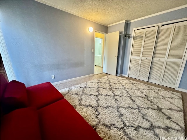 unfurnished bedroom featuring ornamental molding, carpet, a textured ceiling, and a closet