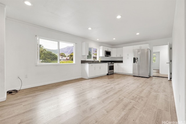 kitchen featuring white cabinets, light hardwood / wood-style flooring, sink, crown molding, and stainless steel appliances