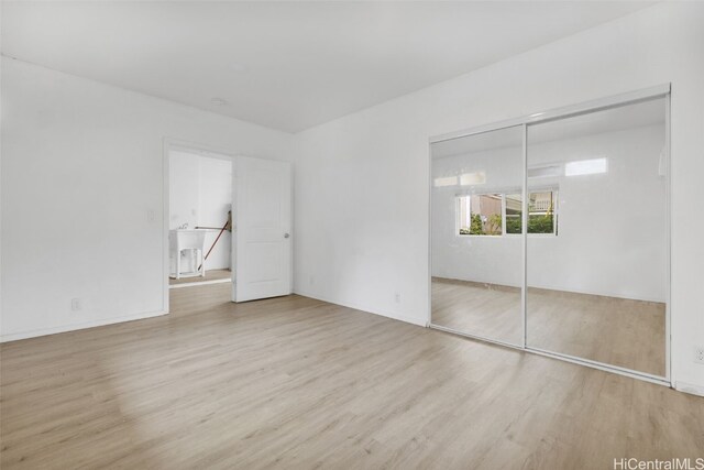 unfurnished bedroom with sink, a closet, and light wood-type flooring