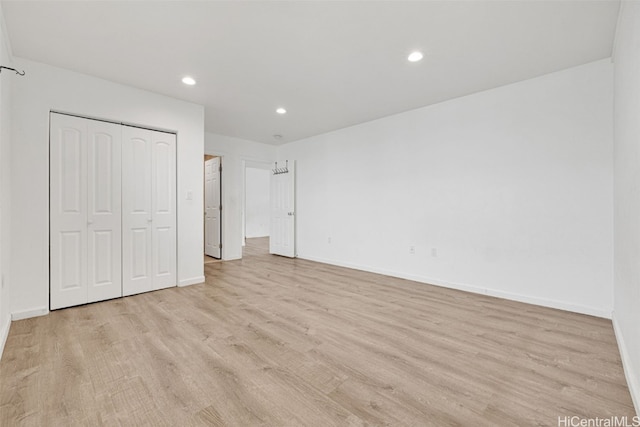 unfurnished bedroom with a closet and light wood-type flooring