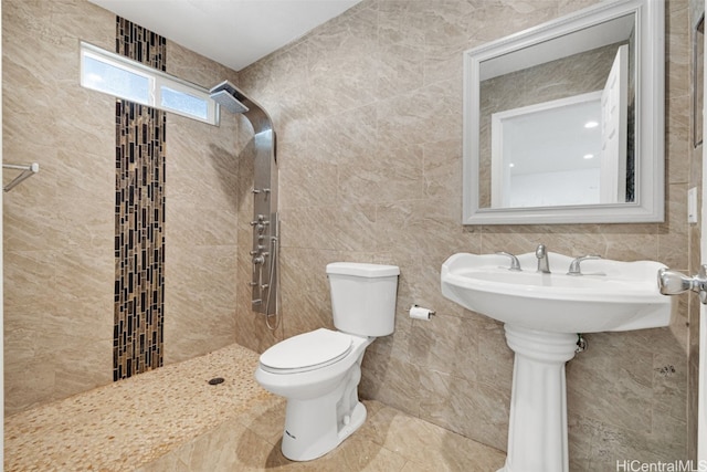 bathroom with tile walls, a tile shower, and toilet