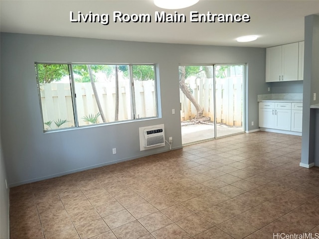 unfurnished living room with light tile patterned flooring and a wall mounted AC