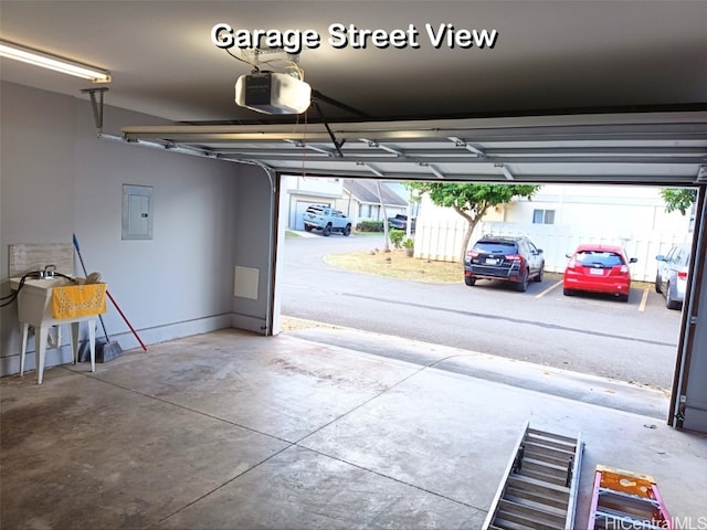 garage featuring a garage door opener, sink, and electric panel