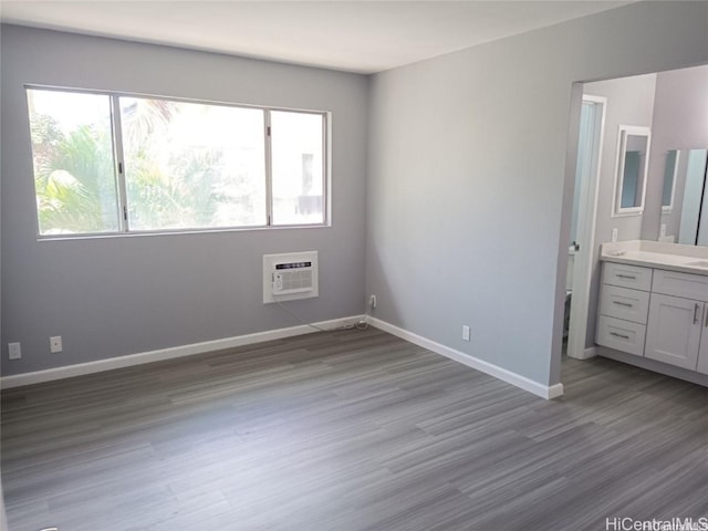 91-1021 Kuina St Unit 119, Ewa Beach, HI 96706 - unfurnished bedroom with baseboards, ensuite bath, wood finished floors, and a wall mounted AC