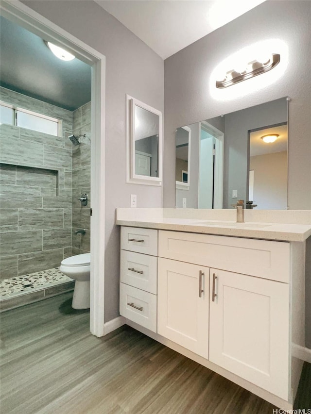 91-1021 Kuina St Unit 119, Ewa Beach, HI 96706 - bathroom with toilet, tiled shower, baseboards, wood finished floors, and vanity