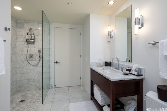 bathroom with vanity, a tile shower, and toilet