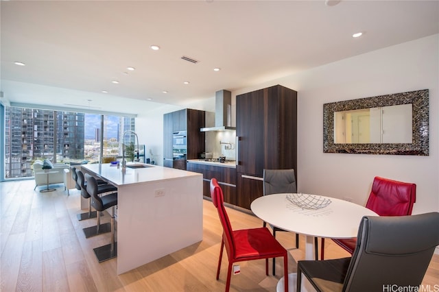 dining area featuring light hardwood / wood-style floors, sink, and floor to ceiling windows