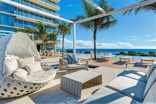 view of patio / terrace with a water view, a balcony, and outdoor lounge area