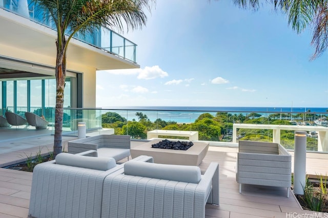 deck with an outdoor living space and a water view