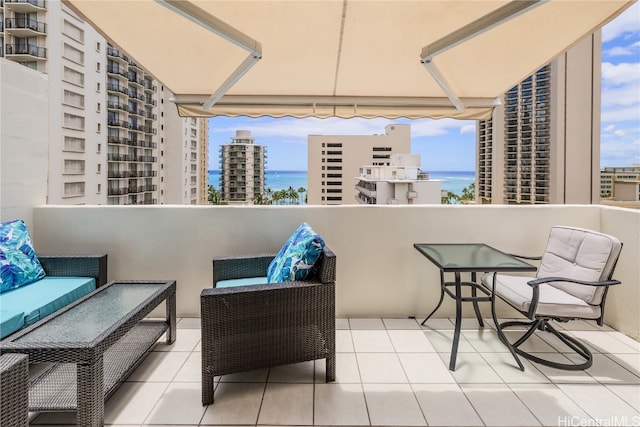 balcony with an outdoor living space and a water view