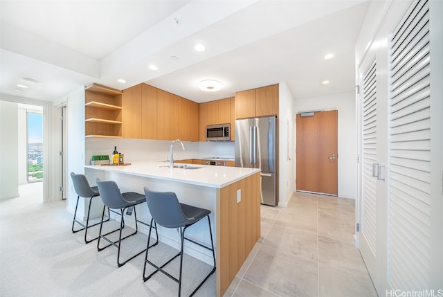 kitchen featuring sink, kitchen peninsula, a breakfast bar area, stainless steel appliances, and light tile patterned floors