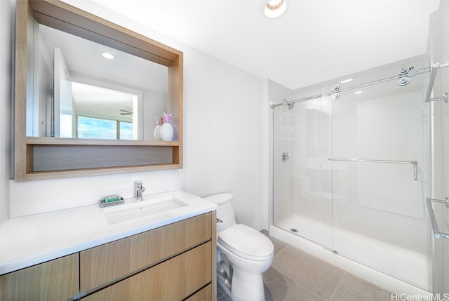 bathroom featuring vanity, a shower with shower door, toilet, and tile patterned flooring