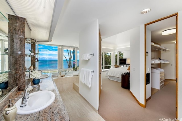 bathroom with vanity and tiled tub