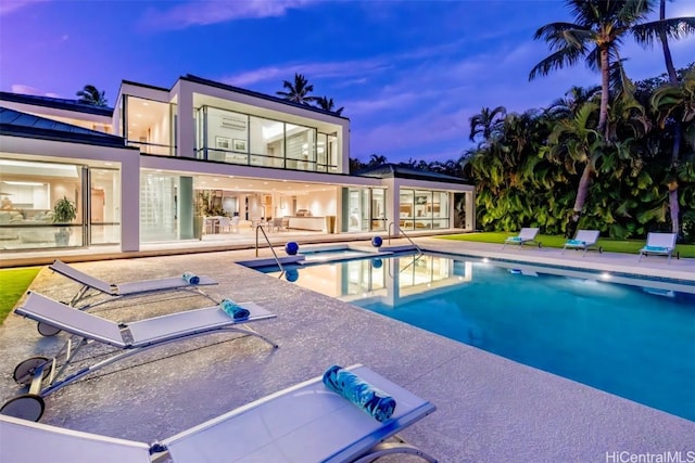 pool at dusk featuring a patio